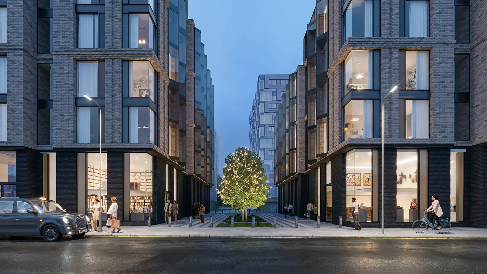 Urban mixed-use brick development at dusk with retail ground floor and pedestrian plaza centred on illuminated tree